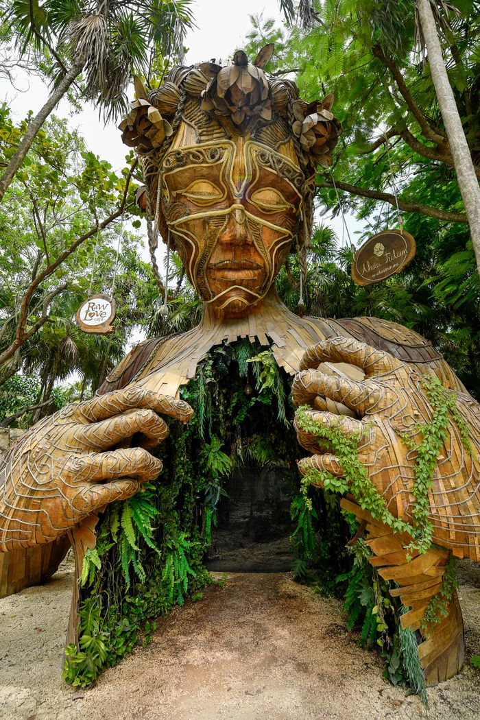 Wooden art installation "Ven a la Luz" in Tulum, blending nature and contemporary symbolism.